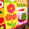 up close of garden flower, veggie and critter themed quilt kit
