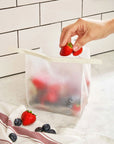 model putting strawberries in roll tight freezer bag