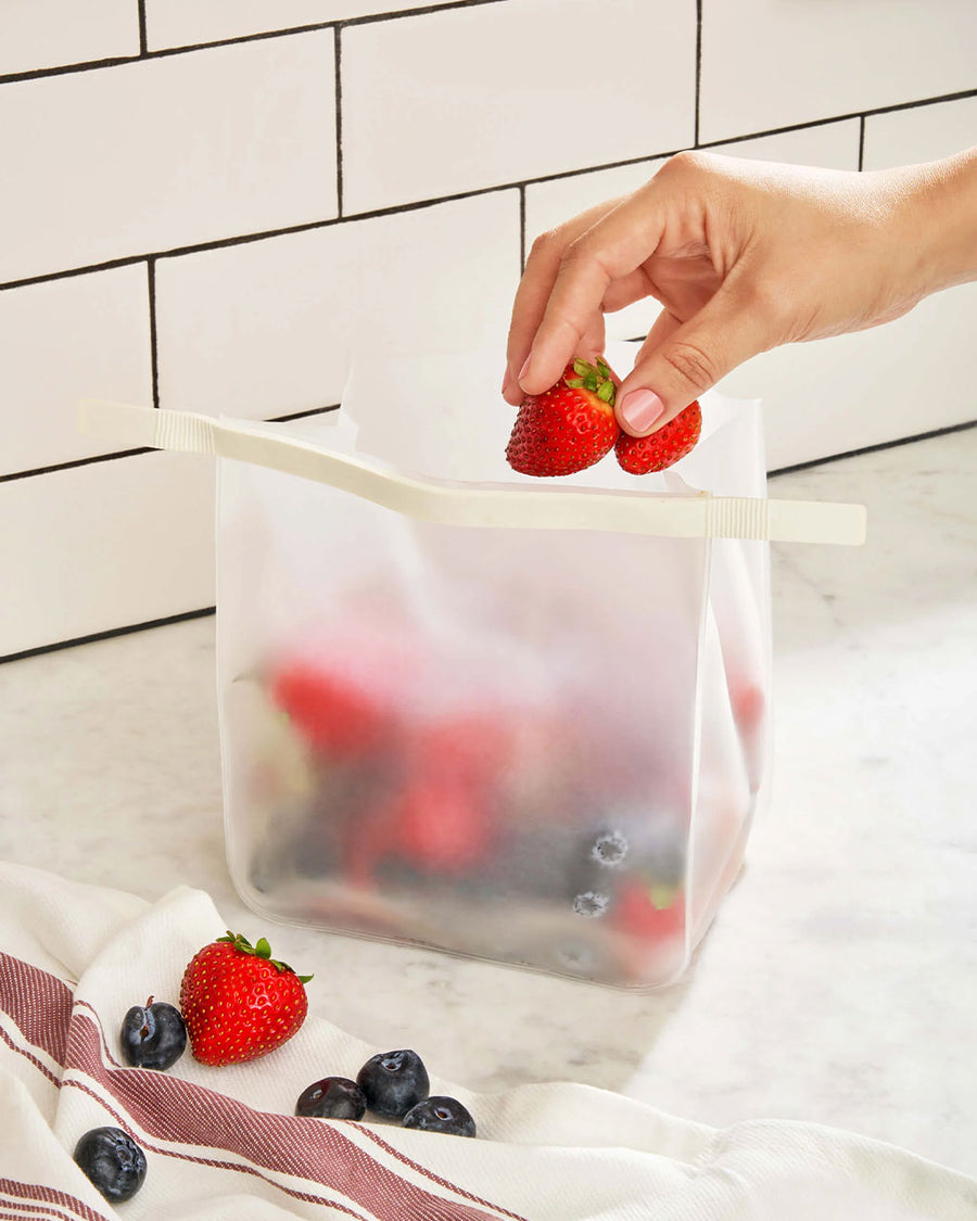 model putting strawberries in roll tight freezer bag