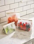set of 3 roll tight freezer bags in three sizes with food inside