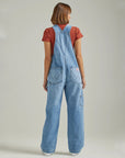 back view of model wearing light blue overalls with carpenter details and back pockets
