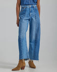 model wearing high waisted wide leg denim with front seams large patch pockets and raw hem
