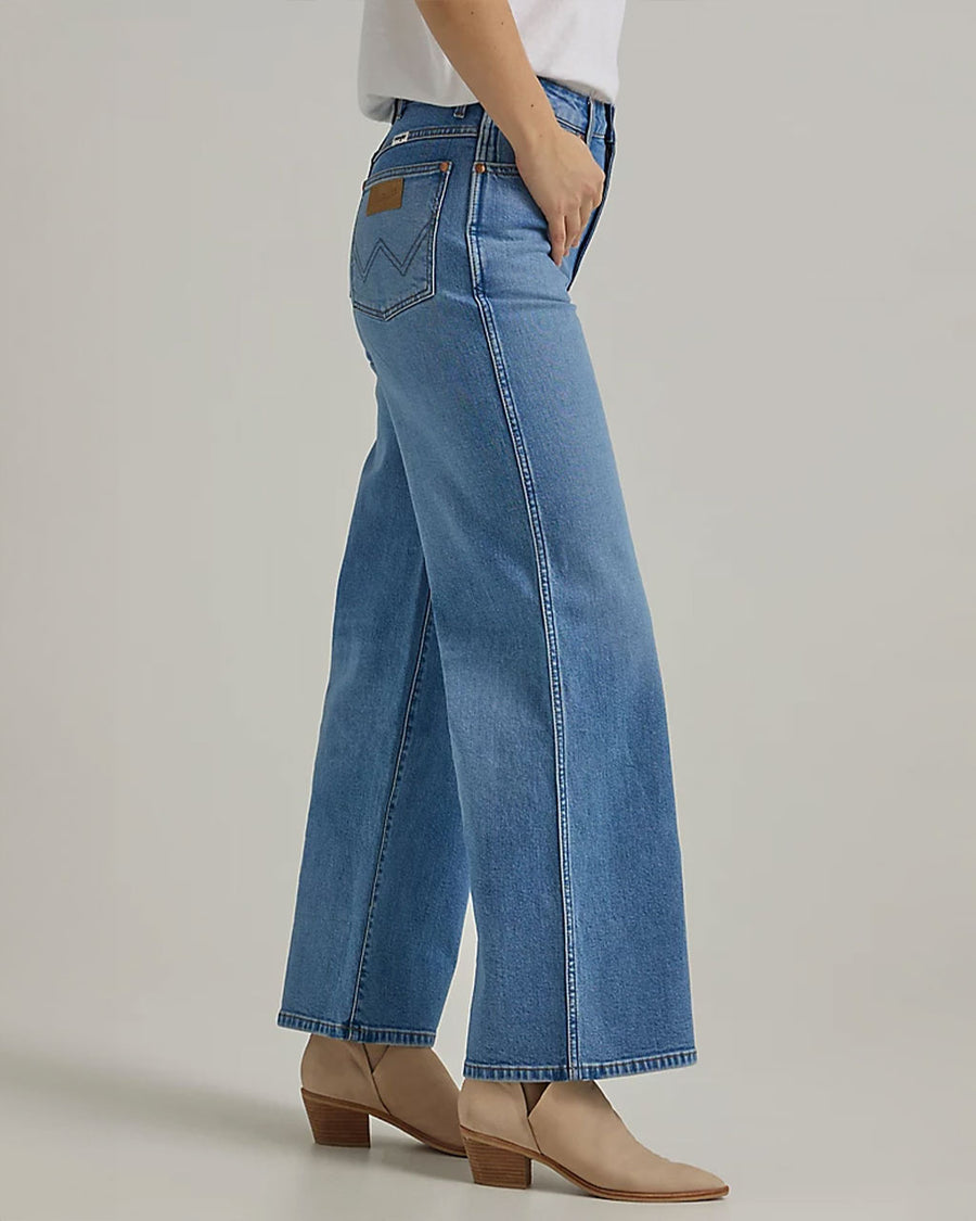 side view of model wearing light blue wide leg jeans