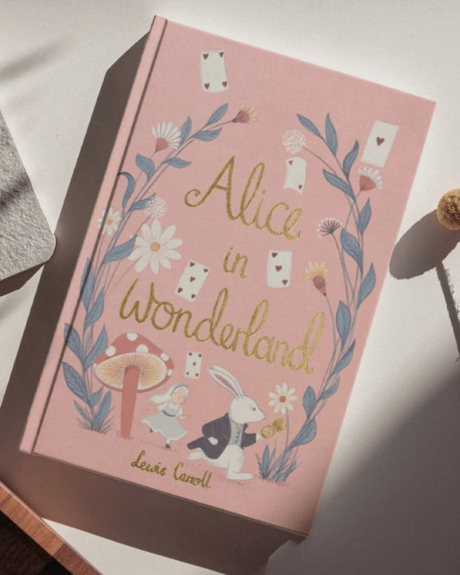 hardcover alice in wonderland book on a table
