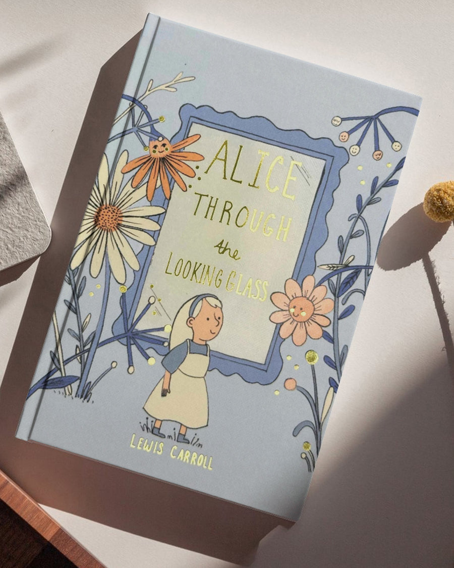 hardcover alice through the looking glass book on a table