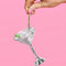 model holding disco martini glass shaped ornament with olive bead stirrer