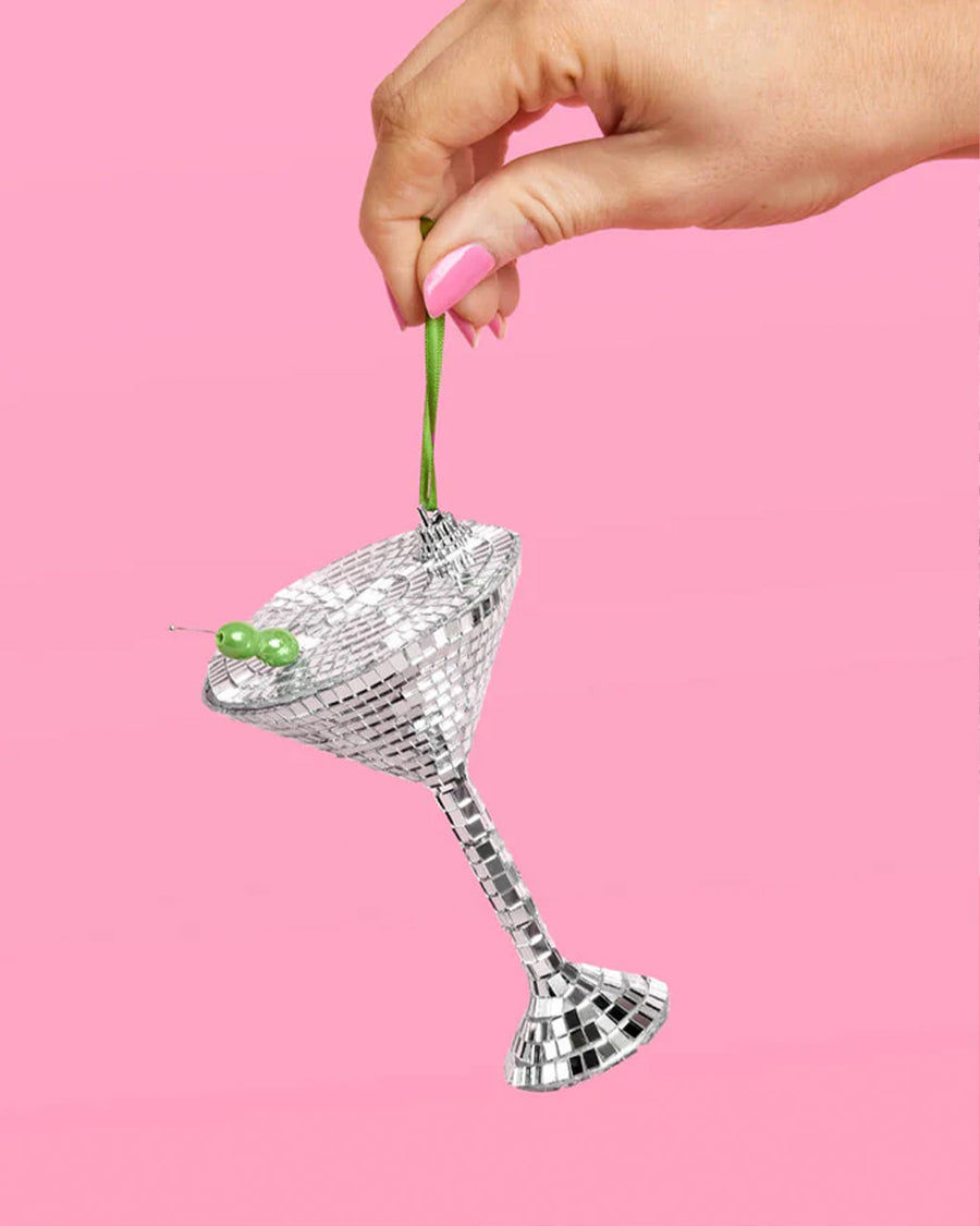 model holding disco martini glass shaped ornament with olive bead stirrer