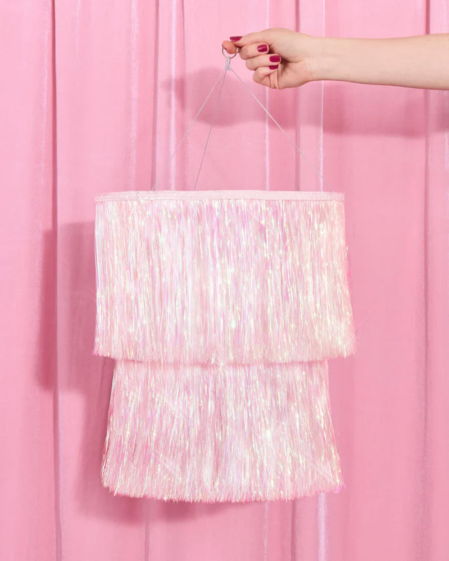 model holding iridescent shimmery fringe double tiered chandelier