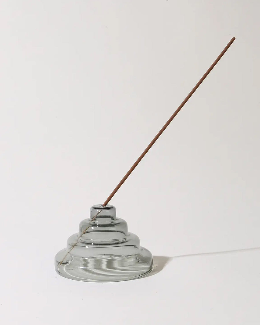 grey stacked glass incense holder with an incense inside