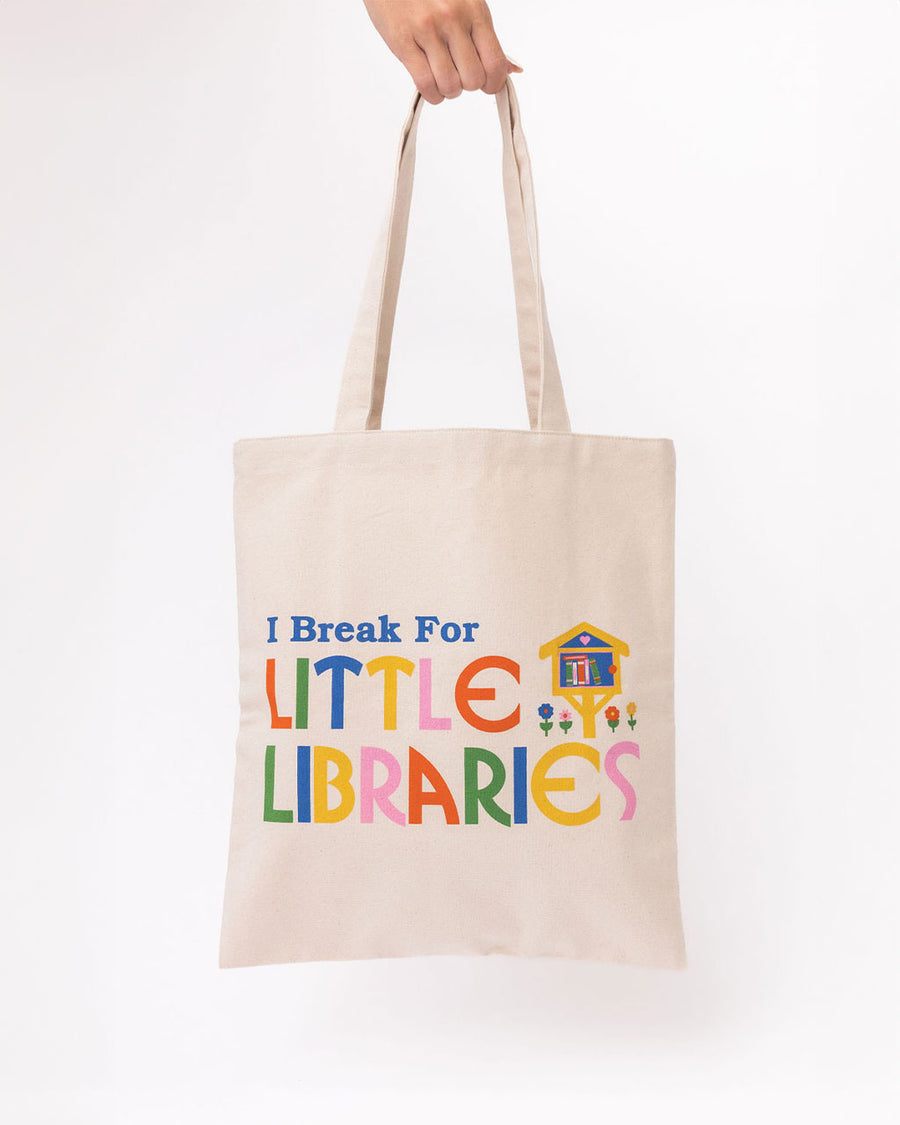 model holding canvas 'i break for little libraries' tote bag