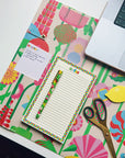 colorful notepad and pen sitting on the floral desk pad
