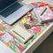 floral desk pad with notepad, planner and laptop on top