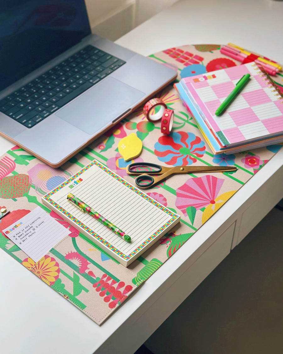 floral desk pad with notepad, planner and laptop on top