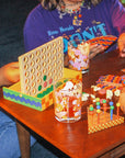 4-in-a-row game on table, with drinks and other games