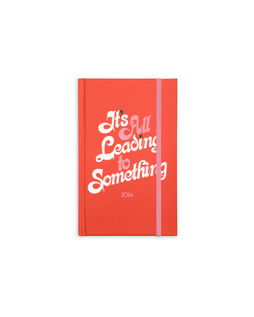 12 month classic planner with red cover and white and pink 'it's all leading to something' across the front