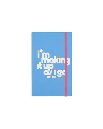 blue 17-month classic planner with white 'i'm making it up as i go' typography with colorful dots on the i's