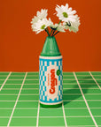 green crayon shaped flower vase with flowers inside