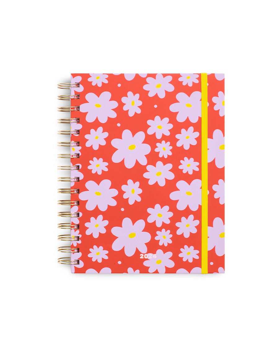 12-month planner with coral red cover with purple abstract flower print and yellow elastic closure strap