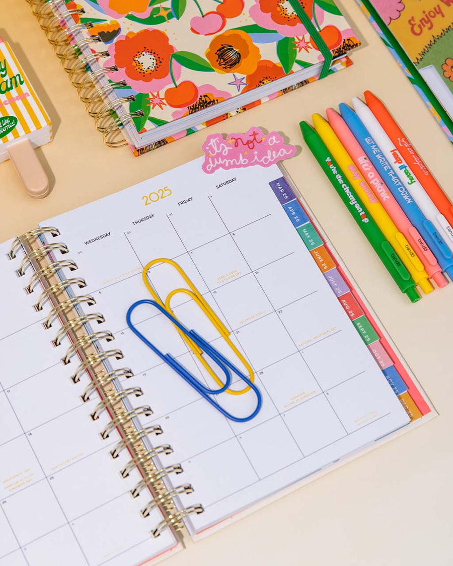 yellow and blue giant paper clips on planner