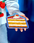 model holding pink and yellow layered cake trinket tray with blue ground