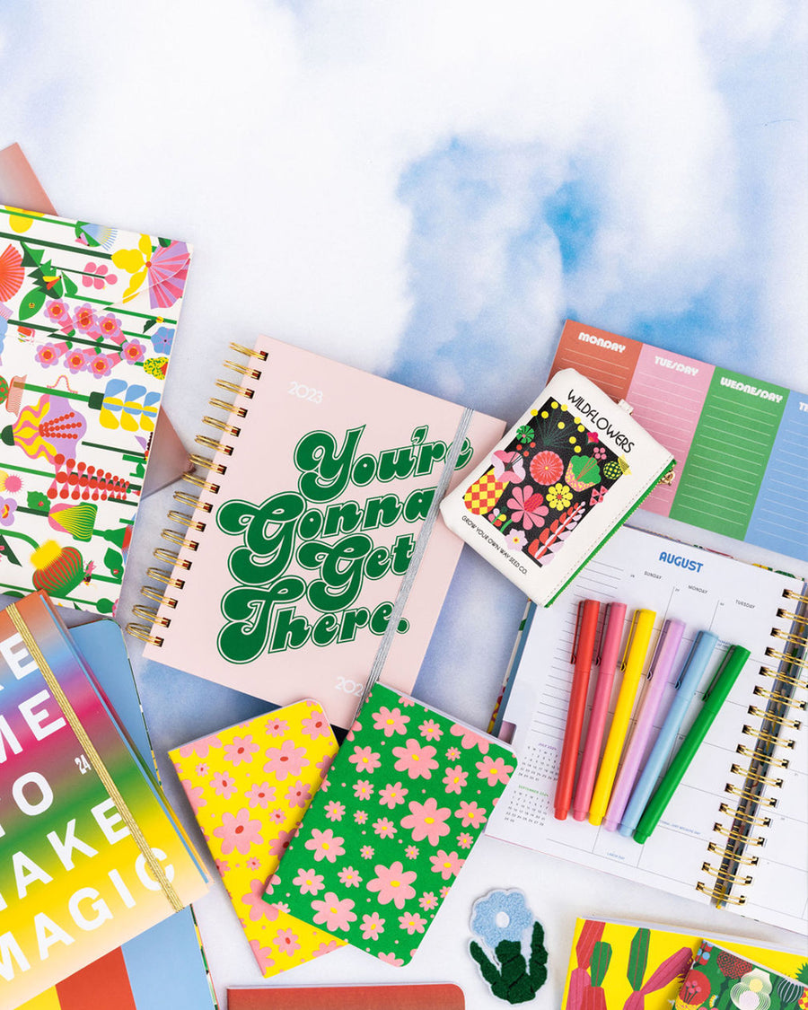 editorial image of set of two notebooks with green ground and pink flowers and yellow ground with pink flowers