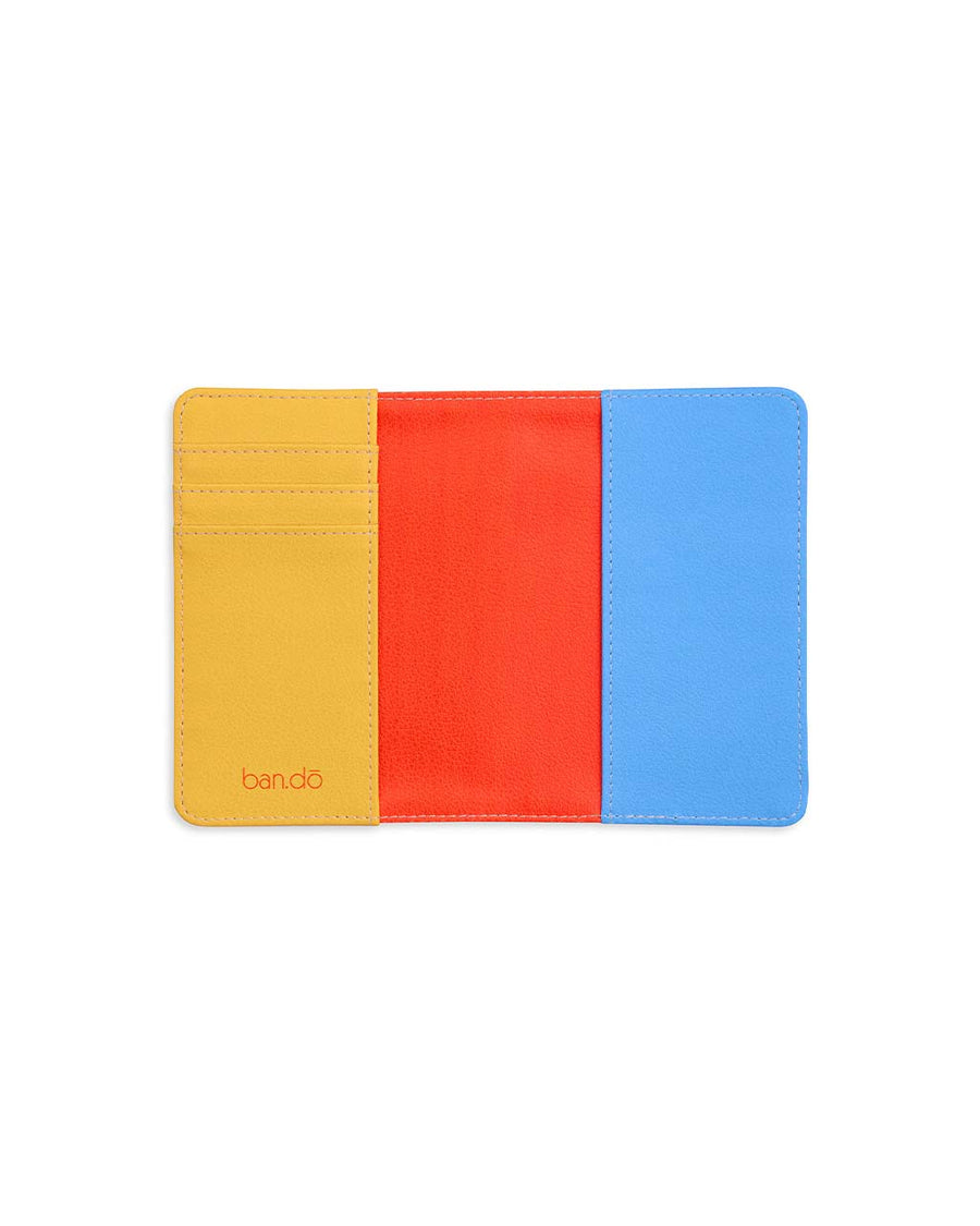 rainbow stripe interior of cream passport holder with retro 'i'd rather be flying' across the front