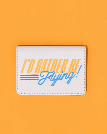 cream passport holder with retro 'i'd rather be flying' across the front on orange ground
