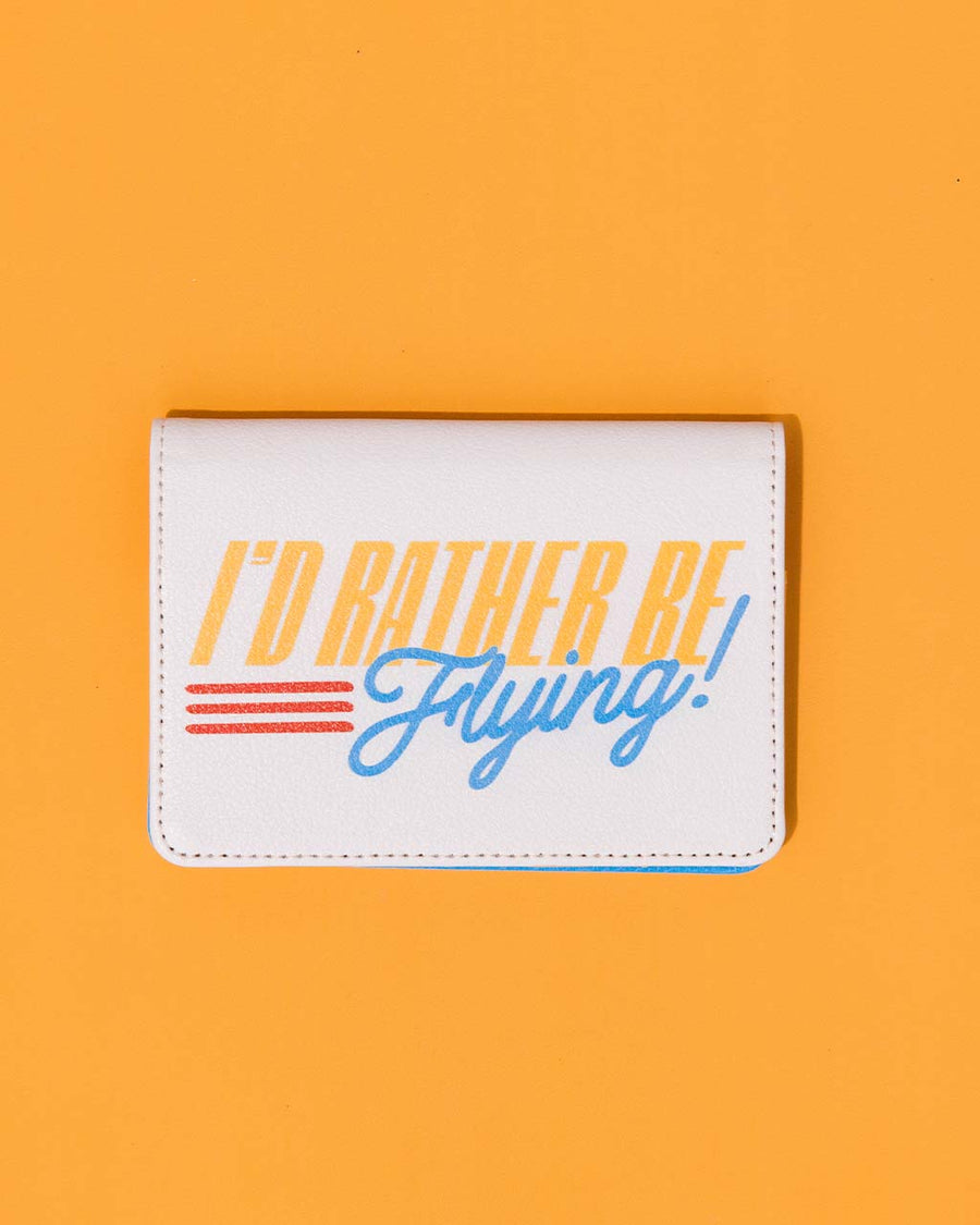 cream passport holder with retro 'i'd rather be flying' across the front on orange ground