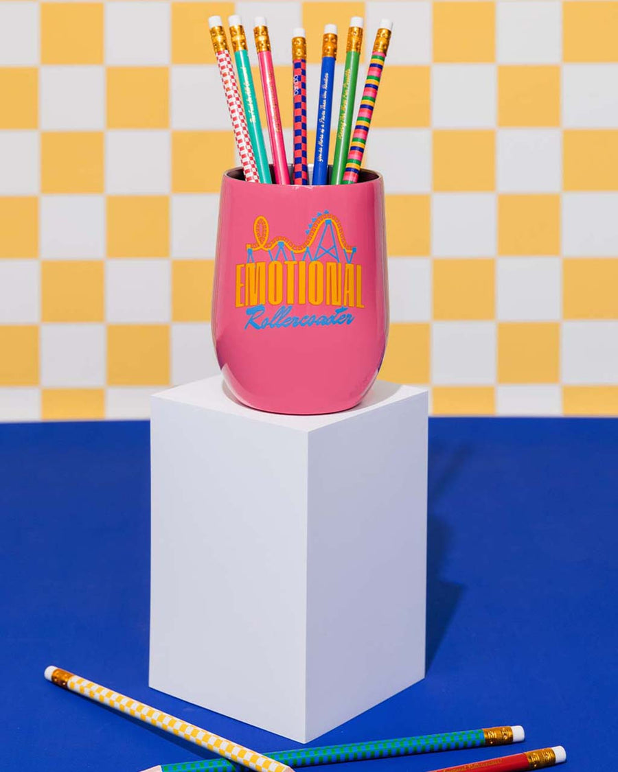 hot pink stainless steel wine glass with 'emotional rollercoaster' across the front and yellow translucent lid with pencils inside