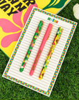set of three pens: yellow geometric floral, pink 'grow your own way', and green geometric floral on notepad