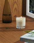 The Le Refuge Dernest candle by Maison Louis Marie is white and comes in a clear glass tumbler on a table
