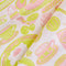 up close of light pink tea towel with yellow and pink breakfast food print