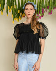model wearing black tulle cropped top with sheer puff sleeves, dot detail and embellished trim on sleeves