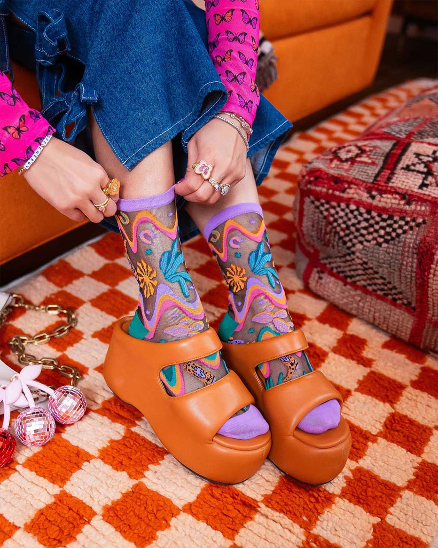 model wearing purple colorful desert floral sheer socks with heels on