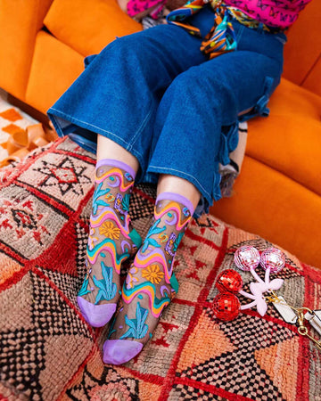 model wearing purple colorful desert floral sheer socks