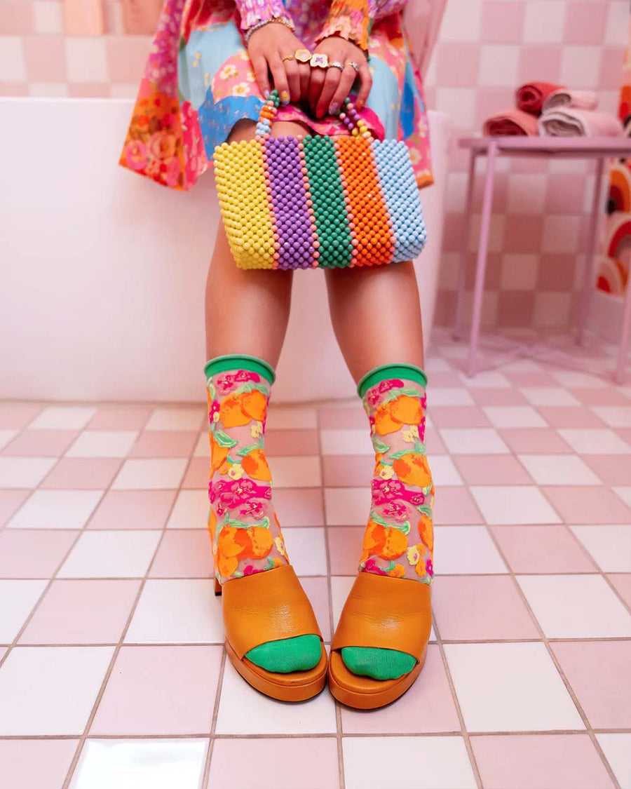 model wearing orange floral sheer socks