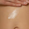 model spreading cedarwood everything lotion on their stomach