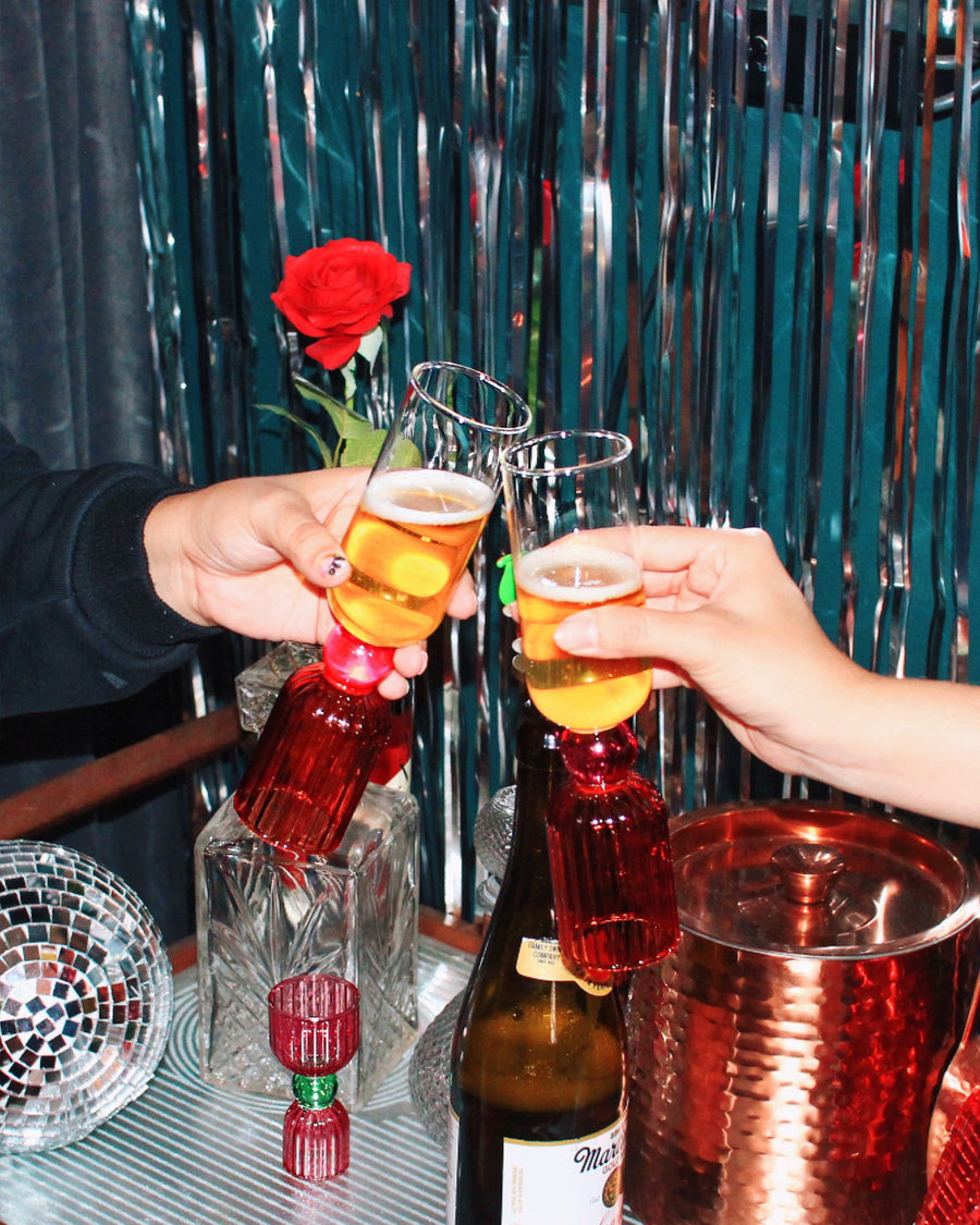 Hands toasting with sparkling beverages in the tipsy turvy bar glasses