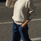 model wearing naturel cable knit crew neck sweater and denim