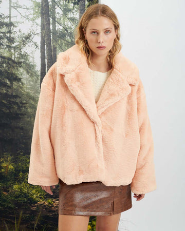 model in a brown mini skirt wearing the veronica faux fur coat