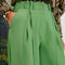 View of model's hand in the pocket of the hollis pear green trousers