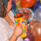 Woman holding yellow Life of the Party Tumbler surrounded by balloons and a disco ball