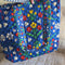 model putting items into blue folk floral tote bag