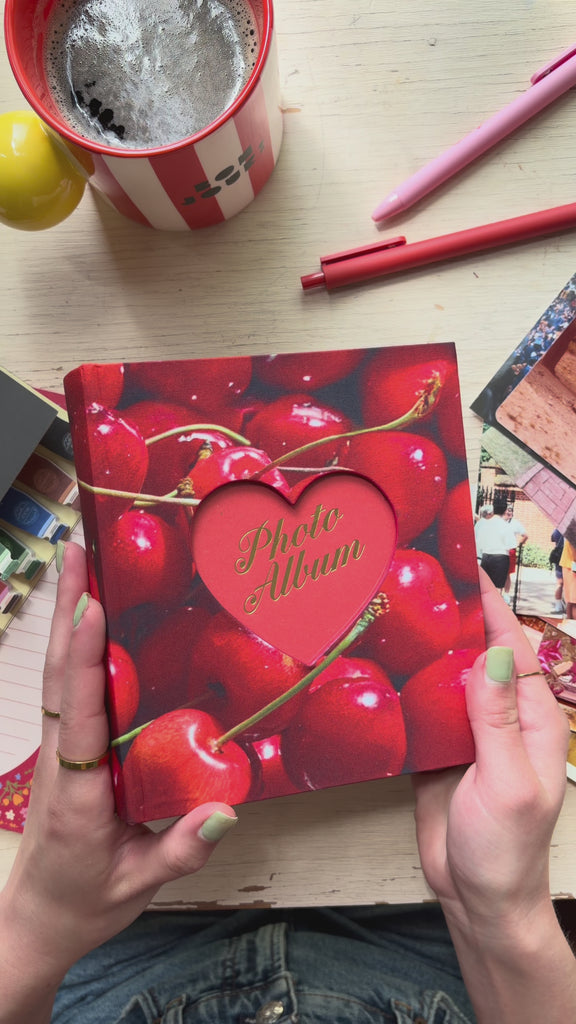 model putting photos into cherry photo album