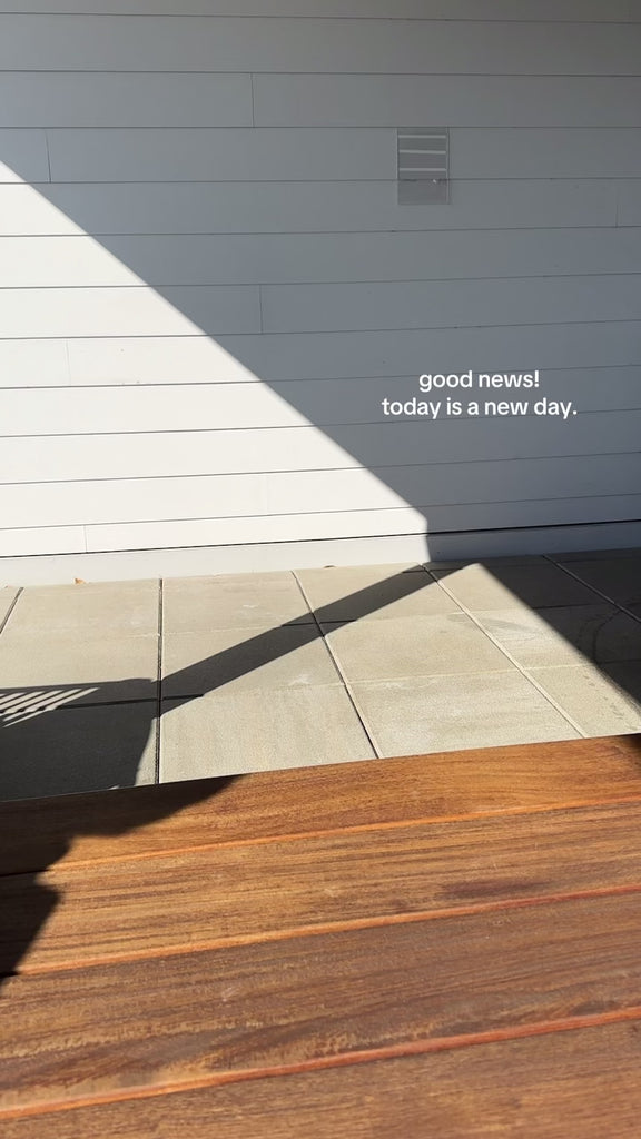 model showcasing folded newspaper vase with red mums in them