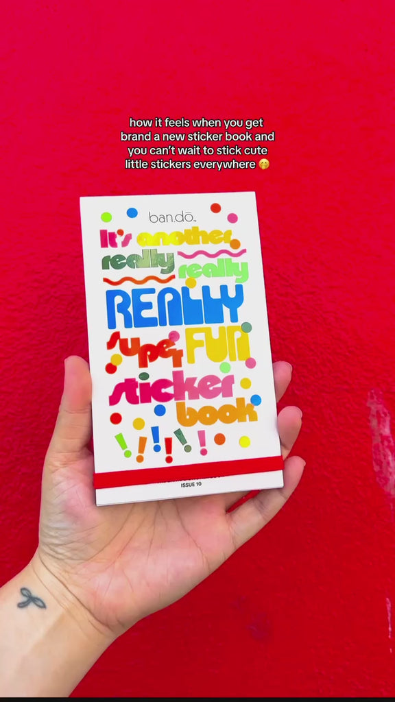 hands flipping through sticker book, featured in front of a red background