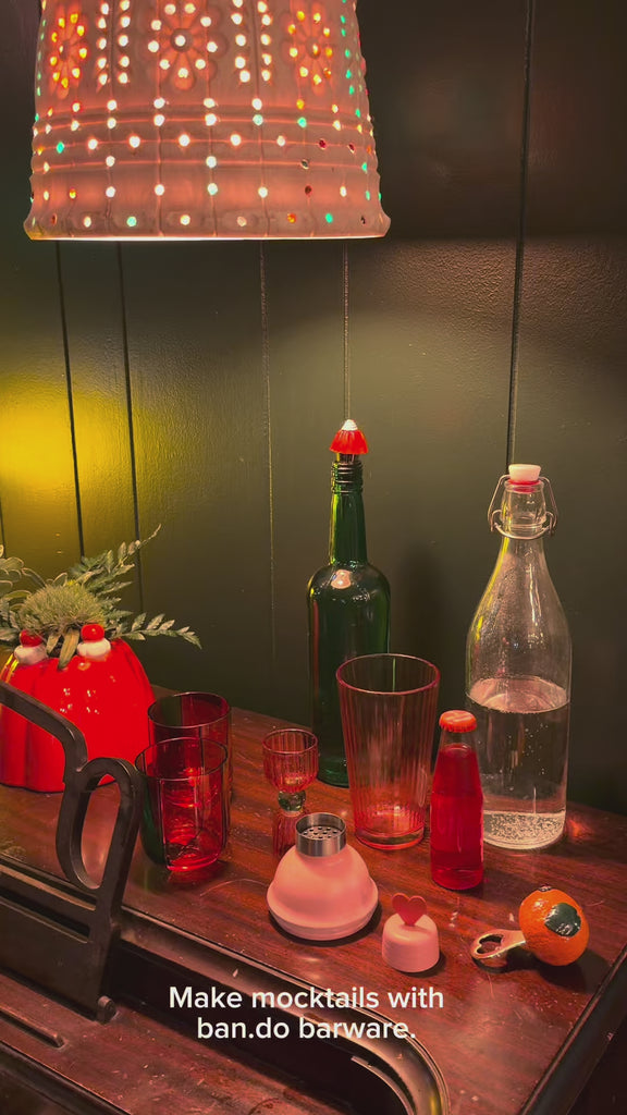 model making a mocktail with barware 