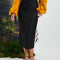 model in a yellow shirt and black shoes wearing the black Tabitha button up midi skirt