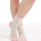 White crew socks with a pink heel and toe cap and multi color confetti dots.