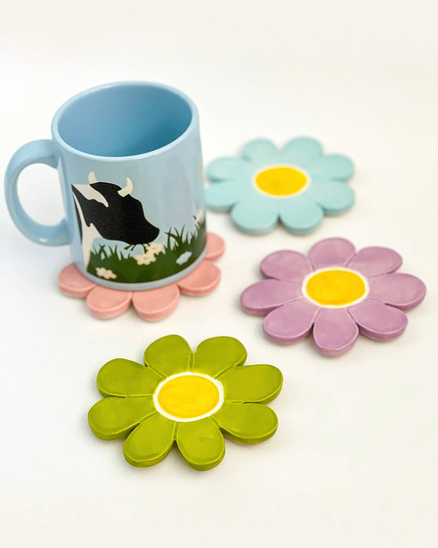 set of four daisy coasters with a mug on one.